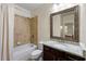 Bright bathroom featuring a granite-topped vanity, framed mirror, and tiled shower and tub at 2808 Broughton Se Ln, Atlanta, GA 30339