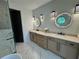Modern bathroom featuring double sinks, stylish vanity, round mirrors with lights, and a glass-enclosed shower at 3960 Clairmont Rd # 2, Chamblee, GA 30341