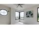Sunlit bedroom featuring unique round window, modern artwork, and corner windows for natural light at 3960 Clairmont Rd # 2, Chamblee, GA 30341