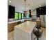 Beautiful kitchen with black cabinets, marble island, stainless appliances, and modern pendant lighting at 3960 Clairmont Rd # 2, Chamblee, GA 30341