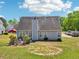 Exterior back of gray home, featuring a well-maintained lawn, with a patio that includes seating and a bbq grill at 1650 Willow River Run, Grayson, GA 30017