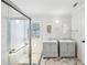 Bathroom featuring double sinks, glass shower door and attractive marble flooring at 1650 Willow River Run, Grayson, GA 30017