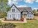 Charming two-story home with blue stucco exterior and lush landscaping on a sunny day at 1650 Willow River Run, Grayson, GA 30017