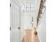 Bright foyer with hardwood floors, white walls, staircase and transom window above front door at 1650 Willow River Run, Grayson, GA 30017