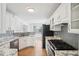 Bright kitchen features white cabinets, stainless steel appliances, and marble countertops at 1650 Willow River Run, Grayson, GA 30017
