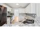 Modern kitchen with white cabinetry, marble countertops, stainless appliances and mosaic backsplash at 1650 Willow River Run, Grayson, GA 30017