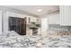 Modern kitchen with white cabinetry, marble countertops, stainless appliances and mosaic backsplash at 1650 Willow River Run, Grayson, GA 30017