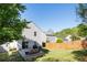 A spacious backyard featuring green grass, a small concrete patio with a furniture set, and a wooden fence at 507 Oakleaf Ct, Acworth, GA 30102