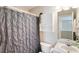 This is a bathroom with a vanity, sink, toilet and bathtub shower with a gray patterned shower curtain at 507 Oakleaf Ct, Acworth, GA 30102