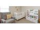 A bedroom with cozy chair, white crib, toys and books on shelving, and a flower decor at 507 Oakleaf Ct, Acworth, GA 30102