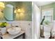 Bathroom features vanity sink, wainscoting and tiled shower with greenery accents at 777 Antone Nw St, Atlanta, GA 30318
