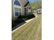 Charming home exterior features arched windows, lush shrubbery, and a well-manicured lawn at 220 Rehobeth Way, Fayetteville, GA 30214