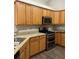 Kitchen with oak cabinets, stainless steel appliances, and stone countertops at 220 Rehobeth Way, Fayetteville, GA 30214