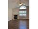 Bright living room features a fireplace and vaulted ceilings with an arched window at 220 Rehobeth Way, Fayetteville, GA 30214