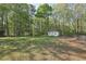 Expansive backyard featuring a storage shed, partial fence, and lush trees at 278 Benjamin Dr, Rockmart, GA 30153