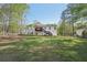 Large, open backyard with lush lawn, mature trees, and the home's rear exterior at 278 Benjamin Dr, Rockmart, GA 30153