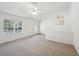 Spacious living room with neutral carpet, ceiling fan, and plenty of natural light from the large front window at 278 Benjamin Dr, Rockmart, GA 30153