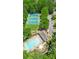 Aerial view of community amenities, including a pool, tennis courts, and playground surrounded by lush greenery at 3531 Vintage Trl, Woodstock, GA 30189
