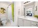 Bathroom with a white vanity, toilet, shower with curtain, and decorative artwork at 3531 Vintage Trl, Woodstock, GA 30189