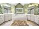Bathroom with dual vanities, soaking tub, and a large window offering natural light at 3531 Vintage Trl, Woodstock, GA 30189