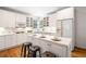Well-lit kitchen with white cabinetry, hardwood floors, and a center island with barstool seating at 3531 Vintage Trl, Woodstock, GA 30189