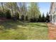 Spacious backyard with lush green grass and mature trees, perfect for outdoor activities at 3825 Raeburn Rd, Cumming, GA 30028