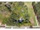 An aerial view showcases a home surrounded by mature trees with views of the adjacent green fields at 4220 Smith Rd, Loganville, GA 30052