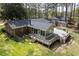 Aerial view of backyard featuring a brick house, large wooden deck, and well-kept lawn at 4220 Smith Rd, Loganville, GA 30052