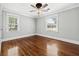 Bedroom featuring hardwood floors, two windows, a modern ceiling fan, and neutral colored walls at 4220 Smith Rd, Loganville, GA 30052