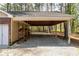 Attached carport and single-car garage with gravel driveway and mature trees at 4220 Smith Rd, Loganville, GA 30052