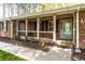 Inviting front porch of brick home with decorative columns and details at 4220 Smith Rd, Loganville, GA 30052