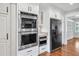 An open kitchen with white cabinets, double ovens, and stainless steel appliances creates a gourmet cooking experience at 4220 Smith Rd, Loganville, GA 30052