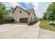 Side view of a brick two-story home with a two-car garage and driveway, surrounded by green landscaping at 5617 Casa Blanca Ln, Atlanta, GA 30331