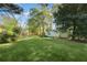 Large, well-maintained backyard with green lawn, mature trees, and storage sheds at 1830 Mayfield Rd, Alpharetta, GA 30009