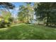 Large backyard with ample greenspace, mature trees, and storage sheds offering plenty of space for Gathering fun and activities at 1830 Mayfield Rd, Alpharetta, GA 30009