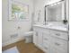 Bathroom with window, updated vanity, neutral walls, and hardwood floors at 1830 Mayfield Rd, Alpharetta, GA 30009