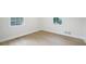 Bright, empty room with wood-look floors, two windows, and white trim details at 1830 Mayfield Rd, Alpharetta, GA 30009