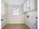 Neat laundry room boasts ample cabinet space and neutral color palette at 1830 Mayfield Rd, Alpharetta, GA 30009