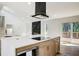 Open-concept kitchen with a center island, modern black range hood, and a fireplace feature wall at 4544 Savage Ne Dr, Marietta, GA 30066