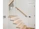 Staircase with light wood steps, black railing, and a white door, creating a modern and clean design at 4544 Savage Ne Dr, Marietta, GA 30066