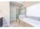 Bathroom showcasing a large tub and glass door shower with gray tile at 1026 Township Sq, Alpharetta, GA 30022