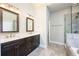 Bright bathroom featuring dark wood cabinets, dual sinks and a glass door shower at 1026 Township Sq, Alpharetta, GA 30022