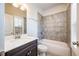 Bright bathroom showcasing a tiled tub and shower combination with a dark wood vanity at 1026 Township Sq, Alpharetta, GA 30022