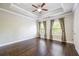 Bedroom with hardwood floors, tray ceilings, crown moulding, three windows and gray curtains at 1026 Township Sq, Alpharetta, GA 30022