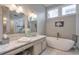 Luxurious bathroom featuring a soaking tub, marble countertops, and decorative mirrors at 1187 Newbridge Ne Trce, Atlanta, GA 30319