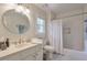 Well-lit bathroom featuring a marble vanity, round mirror, and shower with tub at 1187 Newbridge Ne Trce, Atlanta, GA 30319
