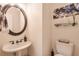 Charming powder room with a pedestal sink, decorative mirror, and modern fixtures at 1187 Newbridge Ne Trce, Atlanta, GA 30319
