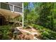 Beautiful backyard features a covered patio with seating, a stone walkway, and mature trees at 155 Palmer Oaks Ln, Marietta, GA 30068