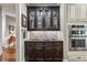 Elegant bar area with dark cabinets, glassware display, and stainless steel appliances for seamless entertaining at 155 Palmer Oaks Ln, Marietta, GA 30068