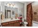 Bathroom features a single sink vanity, large mirror, tiled bathtub, and decorative shower curtain at 155 Palmer Oaks Ln, Marietta, GA 30068